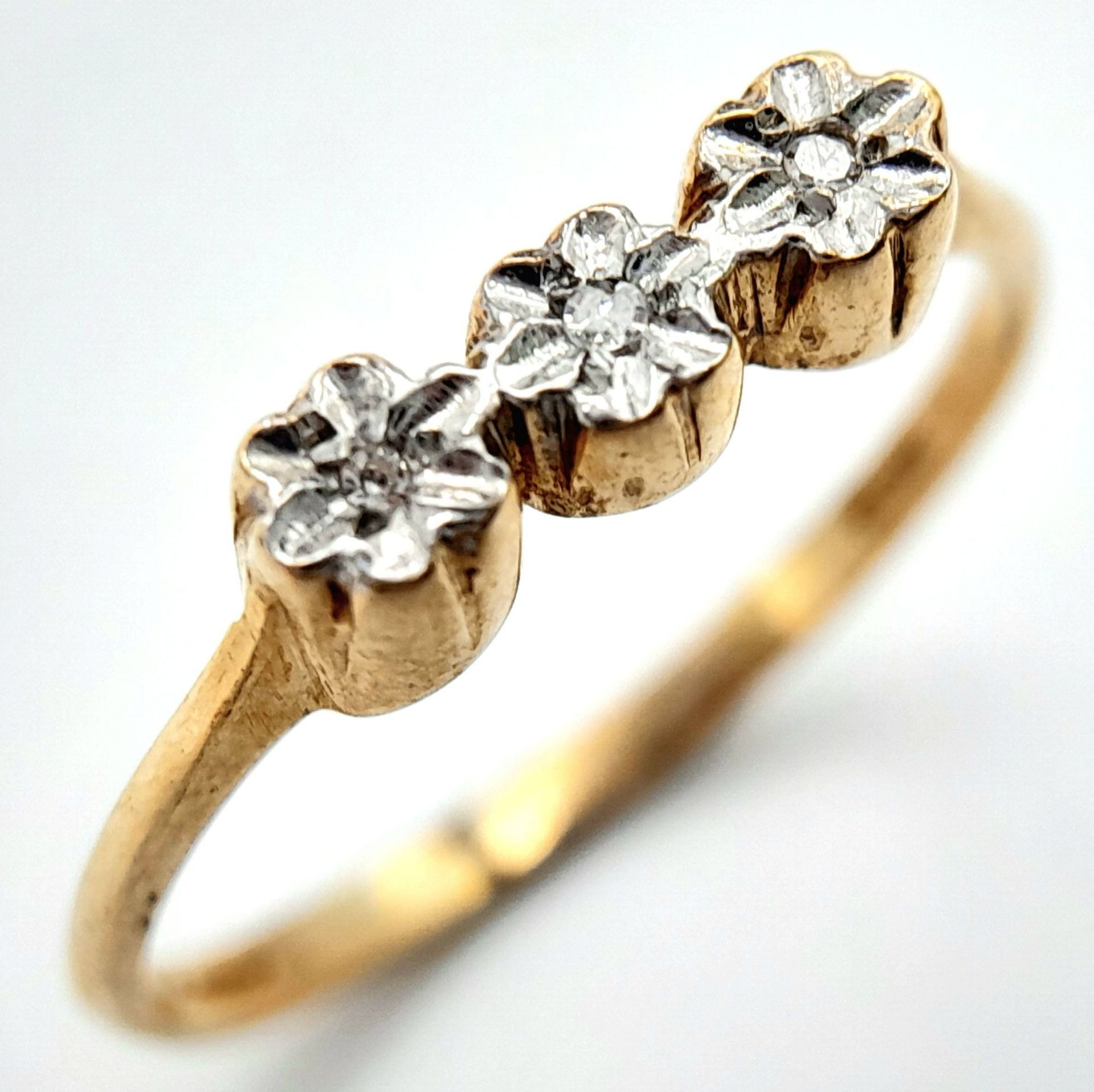 A 9K YELLOW GOLD DIAMOND 3 STONE RING. 1.1G. SIZE M.