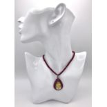 A Citrine and Ruby Pendant with Diamond Surround and Bail - On a Ruby small rondelle necklace with