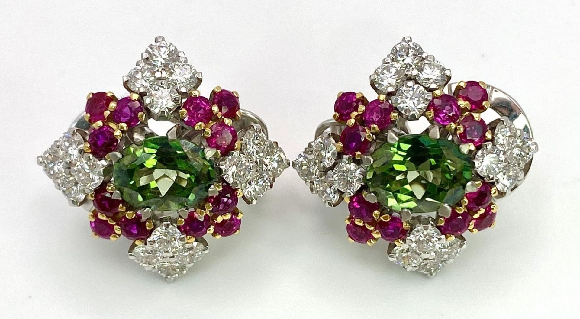 A Pair of Platinum, Emerald, Ruby and Diamond Earrings. Each earring containing a 1.5ct oval cut