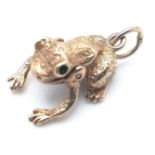A 9K YELLOW GOLD FROG CHARM WITH GREEN EYES AND MOVING FROG LEGS AND MOUTH. 19mm length, 2.6g