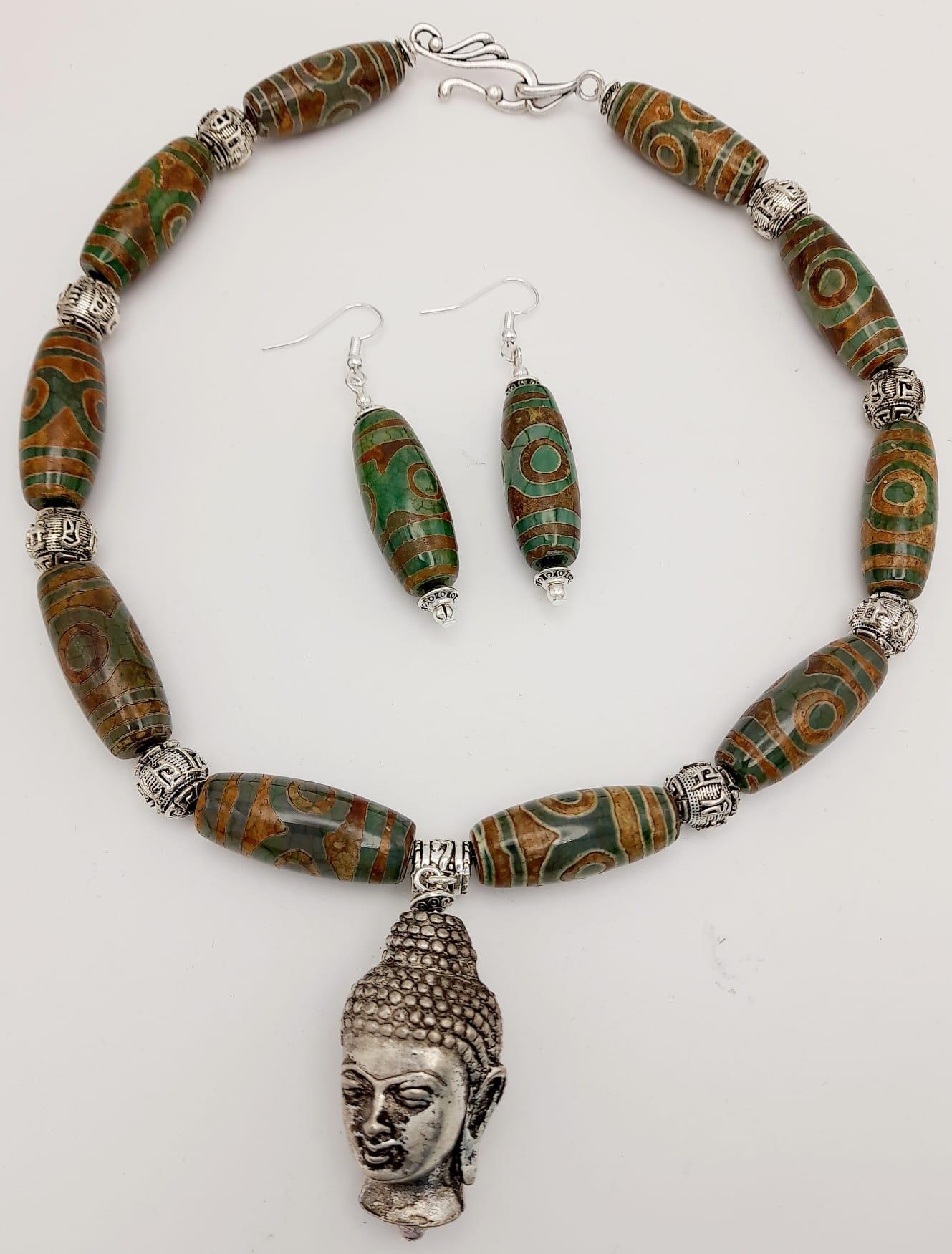 A Tibetan silver, Buddhist, necklace and earrings set with light coloured, three eyed, agate, DZI