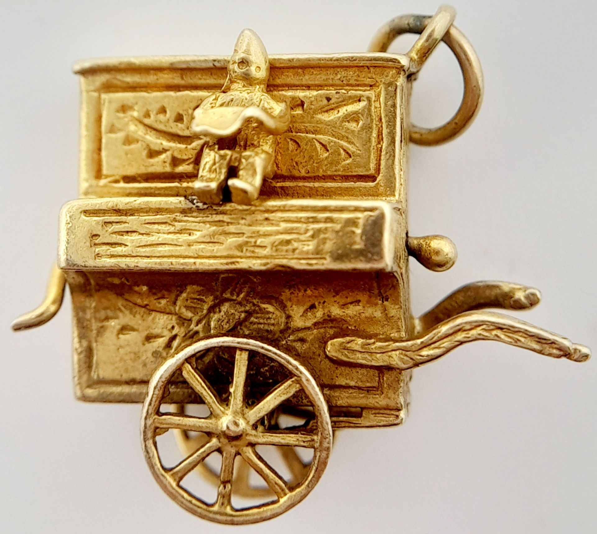 A 9K YELLOW GOLD ORGAN GRINDER AND MONKEY CHARM WITH MOVING PARTS. 2.2cm x 2.5cm, 5.2g weight.