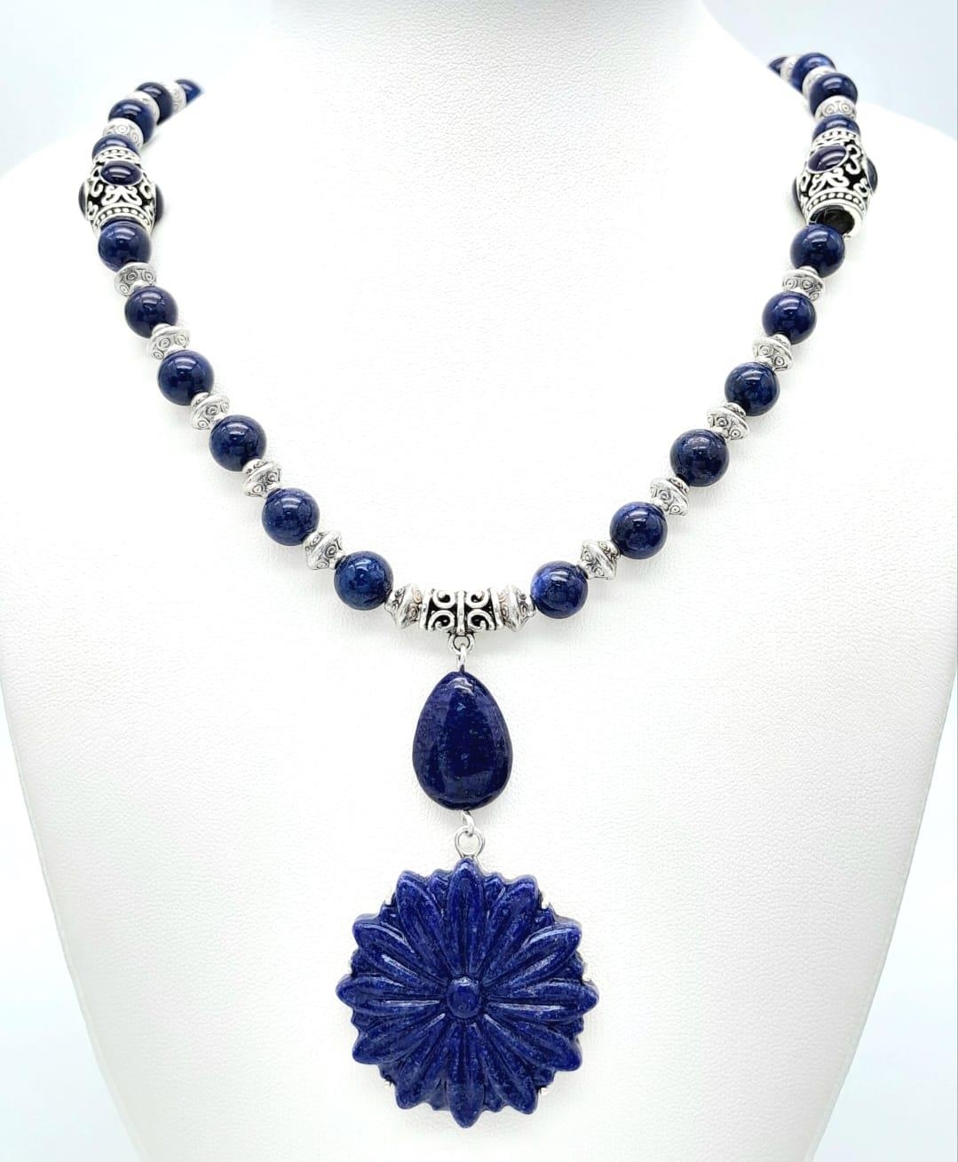 A Tibetan silver and lapis lazuli necklace and earrings set with large, carved, flower shaped discs. - Image 2 of 5