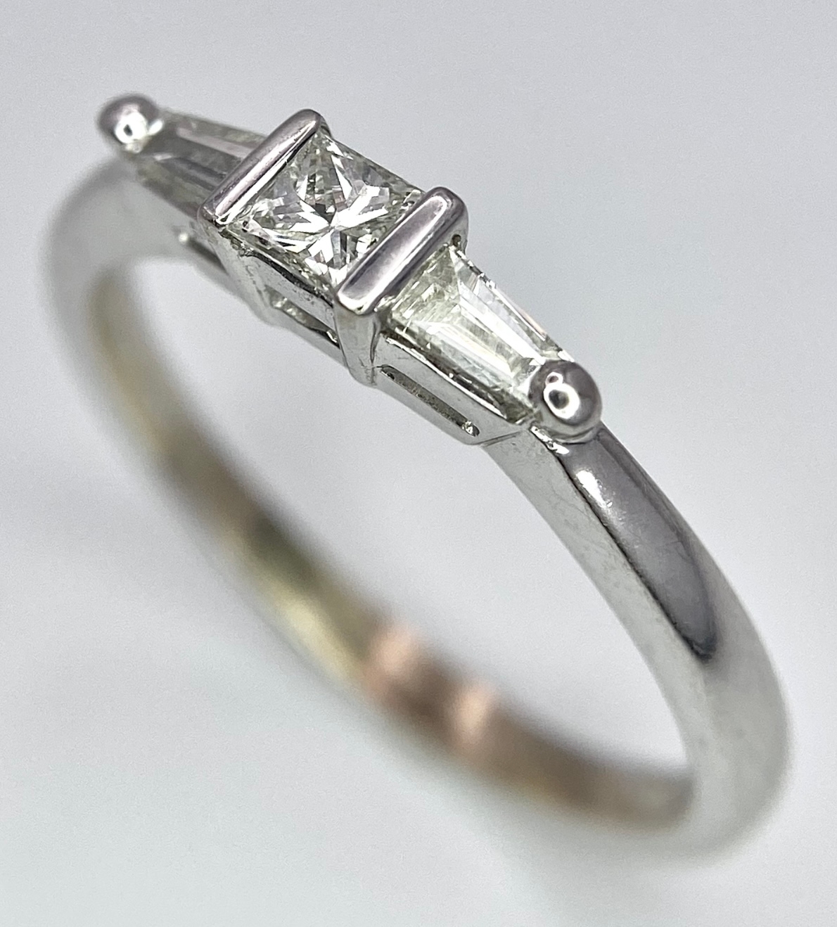 AN 18K WHITE GOLD, DIAMOND 3 STONE RING - PRINCESS CUT CENTRE WITH A TAPPERED BAGUETTE DIAMOND - Image 5 of 7