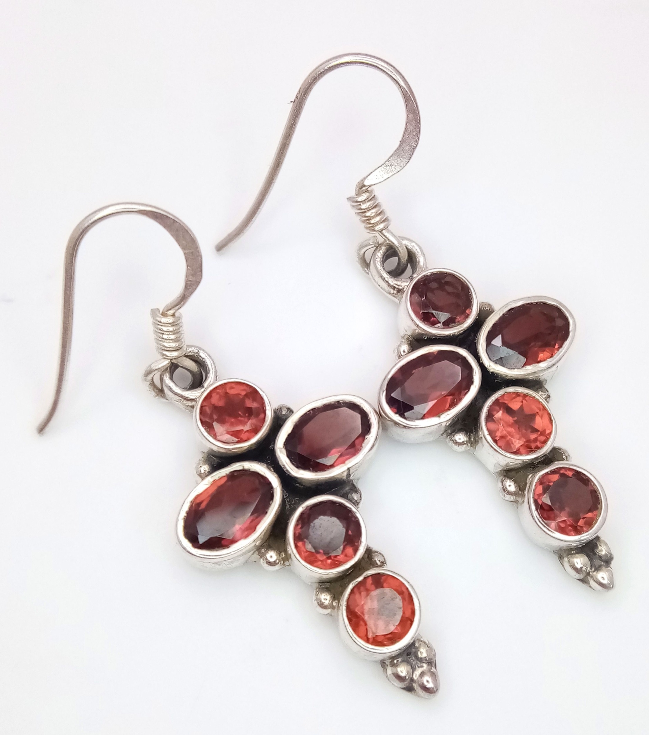 A Pair of Sterling Silver Garnet Set Cross Earrings. 3.5cm drop. 1.4cm Wide and set with 5 Round and