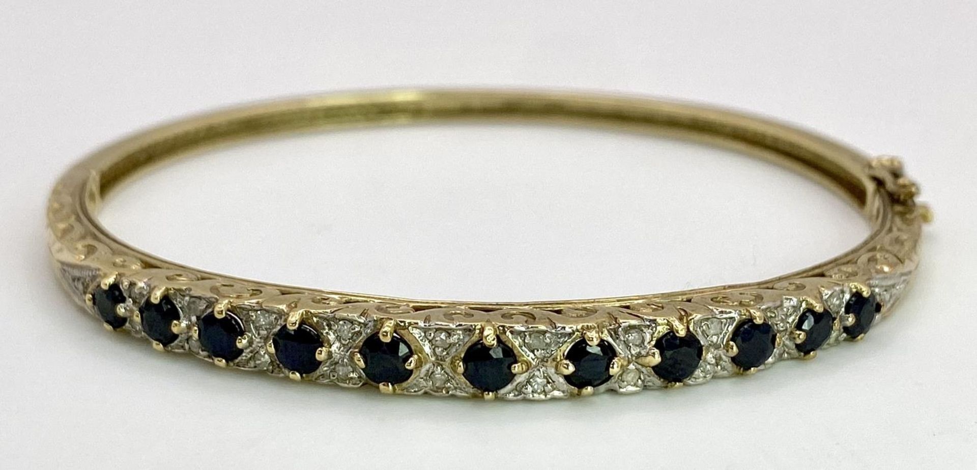 A 9K YELLOW GOLD DIAMOND & SAPPHIRE SET BANGLE 10.4G , 55mm x 63mm diameter. SC 9005