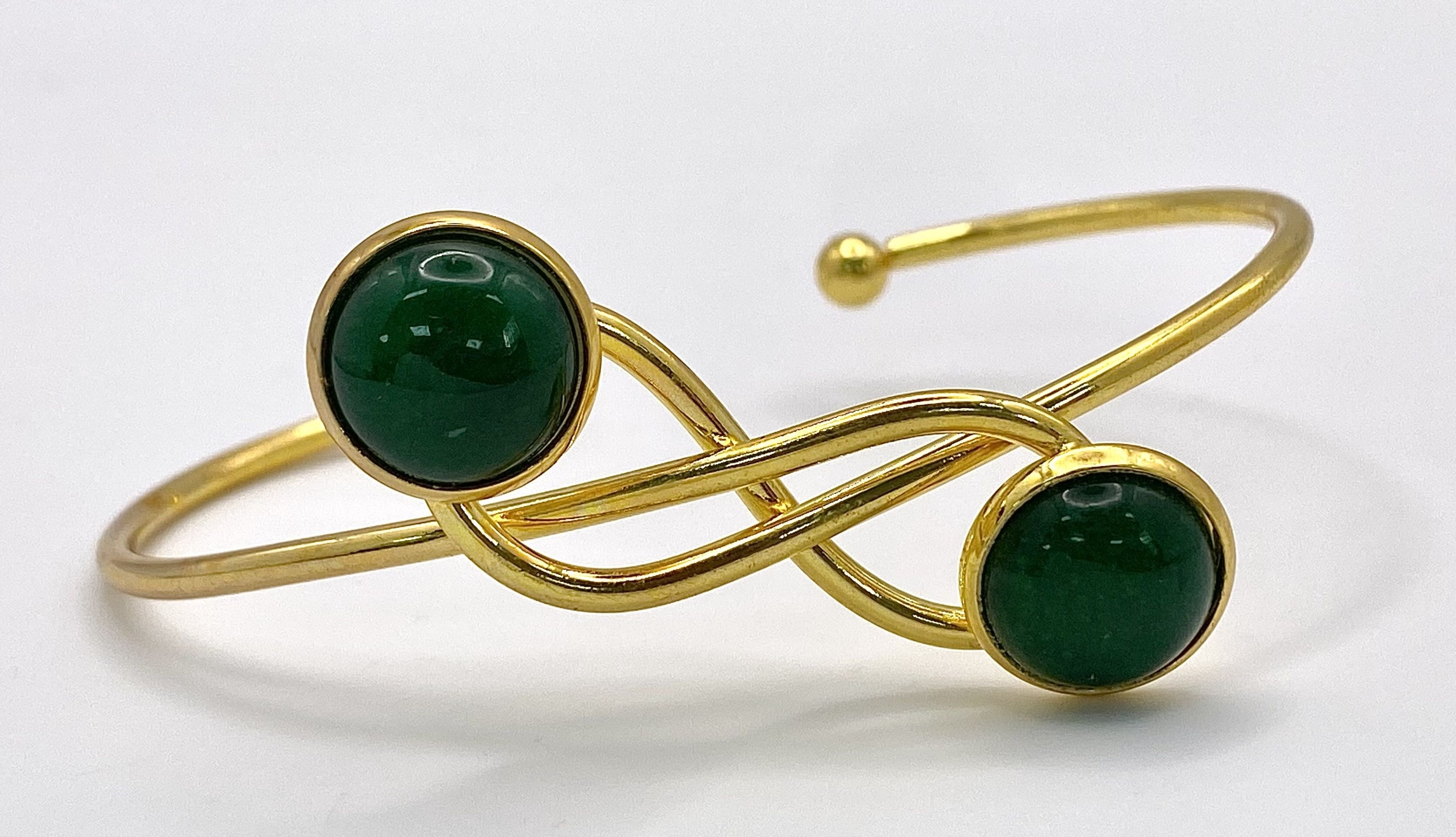 A Gilded Metal Jade Cabochon Crossover Cuff Bangle.