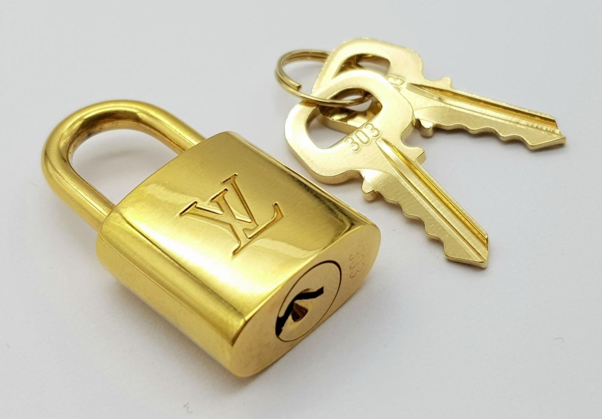 A Louis Vuitton Gold Plated Lock with Two Keys.