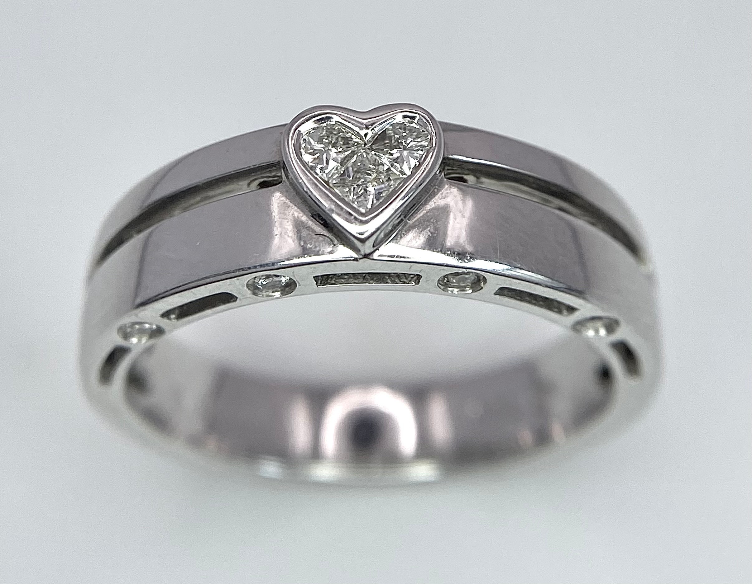 A 18K WHITE GOLD DIAMOND RING, DIAMONDS SET IN HEART SHAPE CENTRE AND DIAMONDS SET ON TWO SIDE 4.