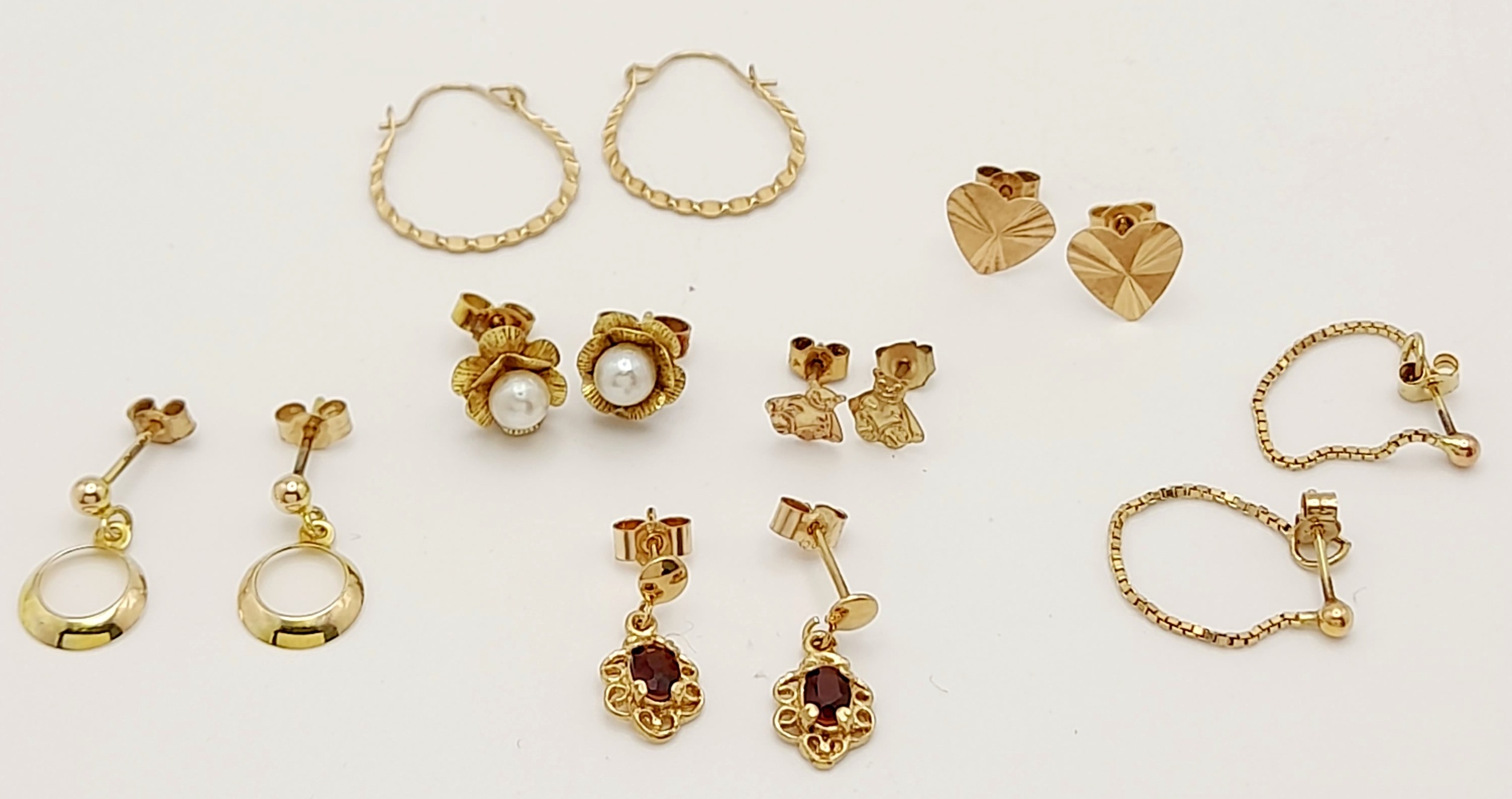 7x pairs of 9ct yellow gold earrings, including garnet and pearl studs, 4.3g total weight. ref: TB01