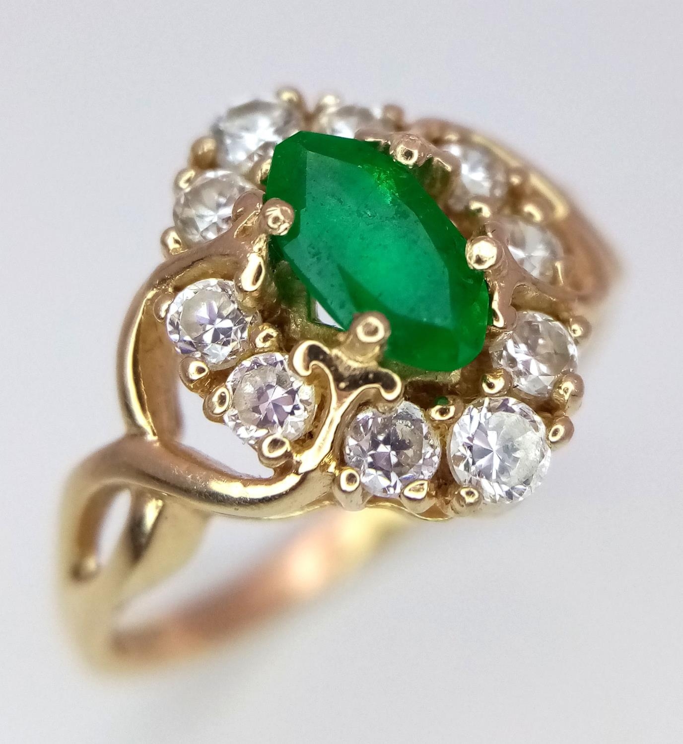 A 14K Yellow Gold Emerald and White Stone Ring. 1.2ct emerald. Size O, 3.34g total weight.