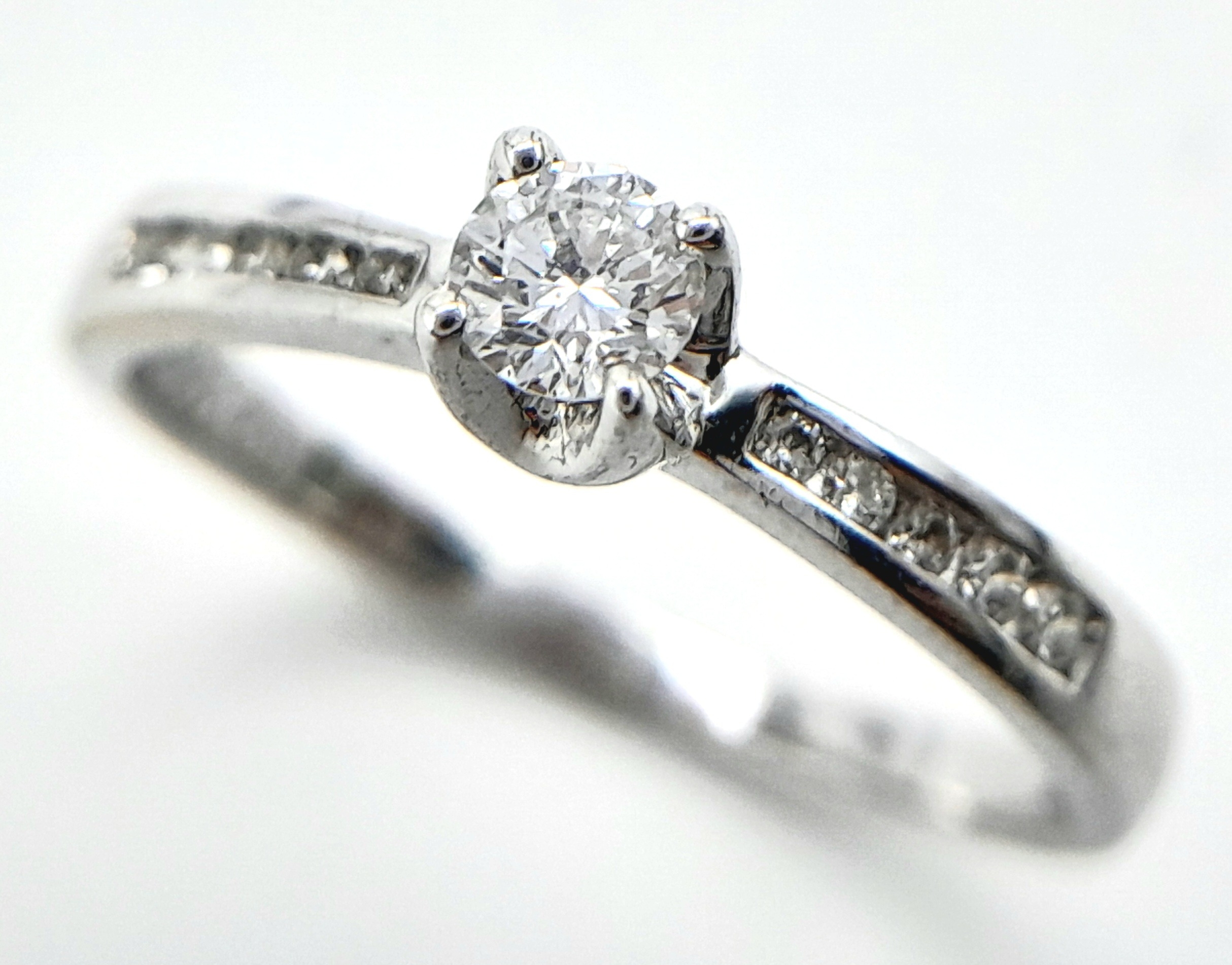 AN 18K WHITE GOLD DIAMOND SOLITAIRE RING - WITH DIAMOND SHOULDERS. 0.25CT. 1.9G. SIZE L - Image 4 of 6