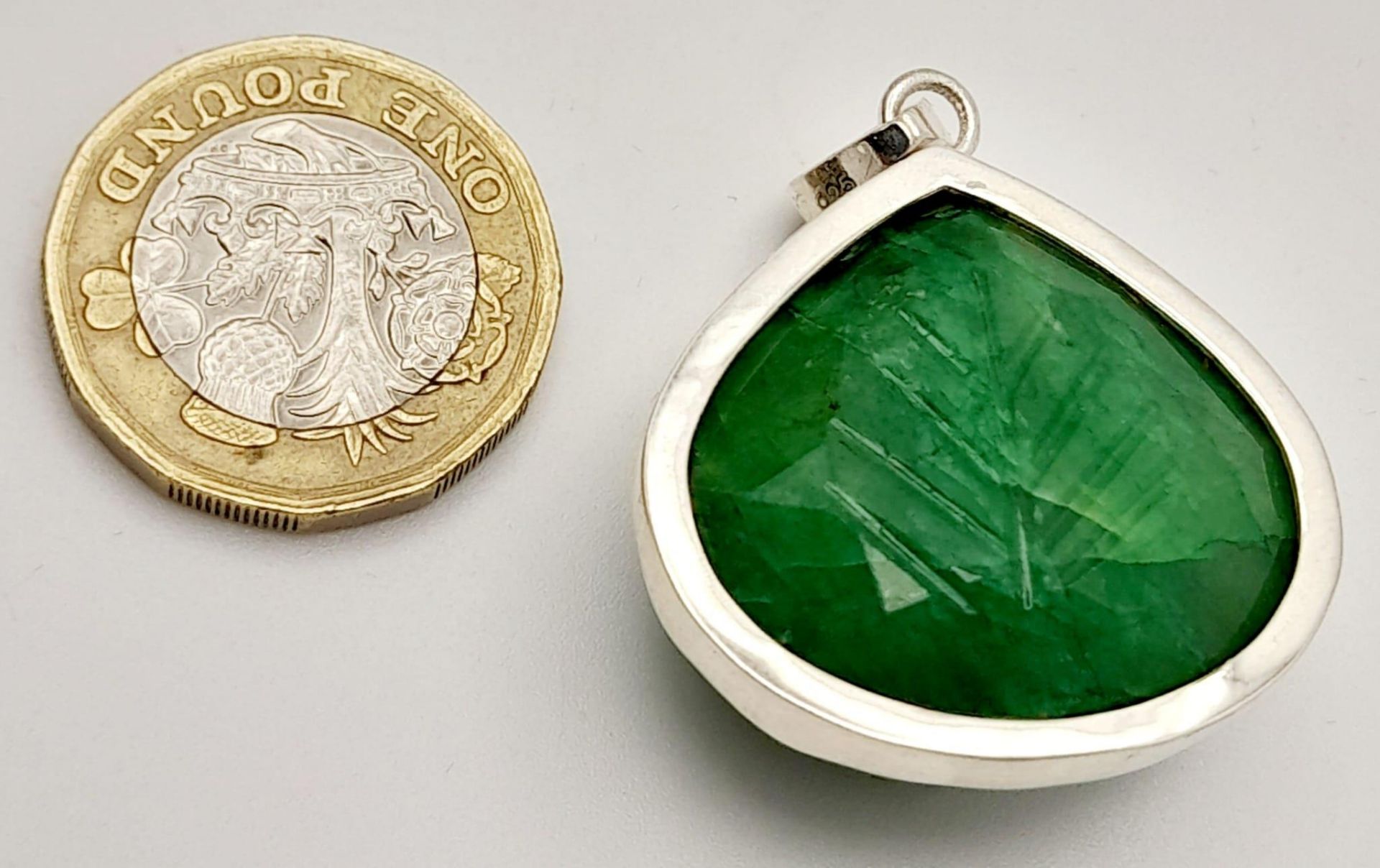 A Carved Trillion Shape 81ct Emerald Pendant set in 925 Silver. 4cm. Comes with a presentation case. - Image 4 of 6