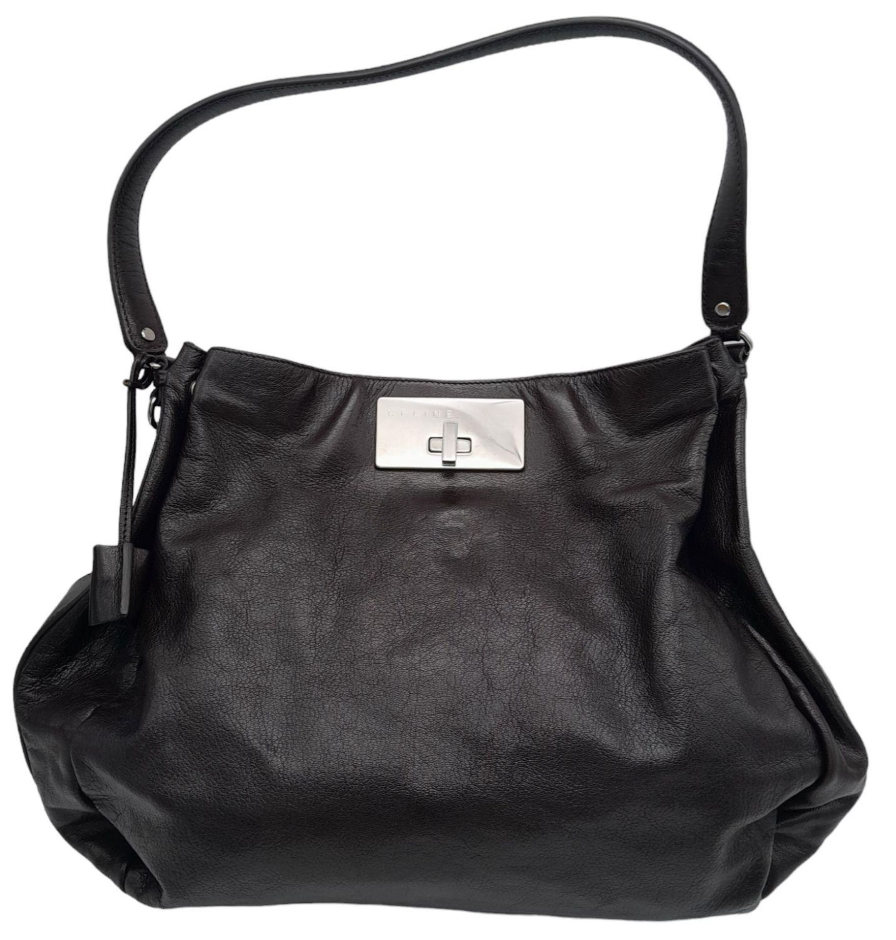 A Celine Dark Brown Shoulder Bag. Leather exterior with silver-toned hardware, single strap, press