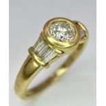 A 9 K yellow gold ring with a round cut diamond and more baguette diamonds on shoulders (one