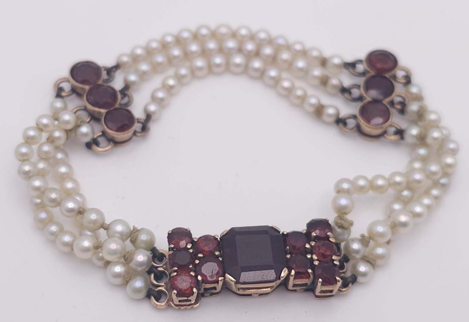 An Antique 9K Gold (tested), Garnet and Pearl Bracelet. Different cuts of rich garnet gemstones