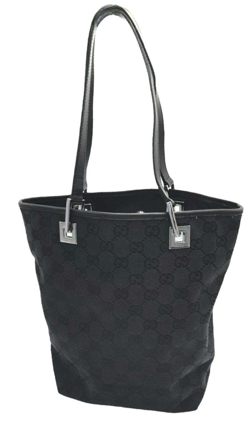 A Gucci Black Monogram Tote Bag. Canvas exterior with leather trim, two leather straps and silver-