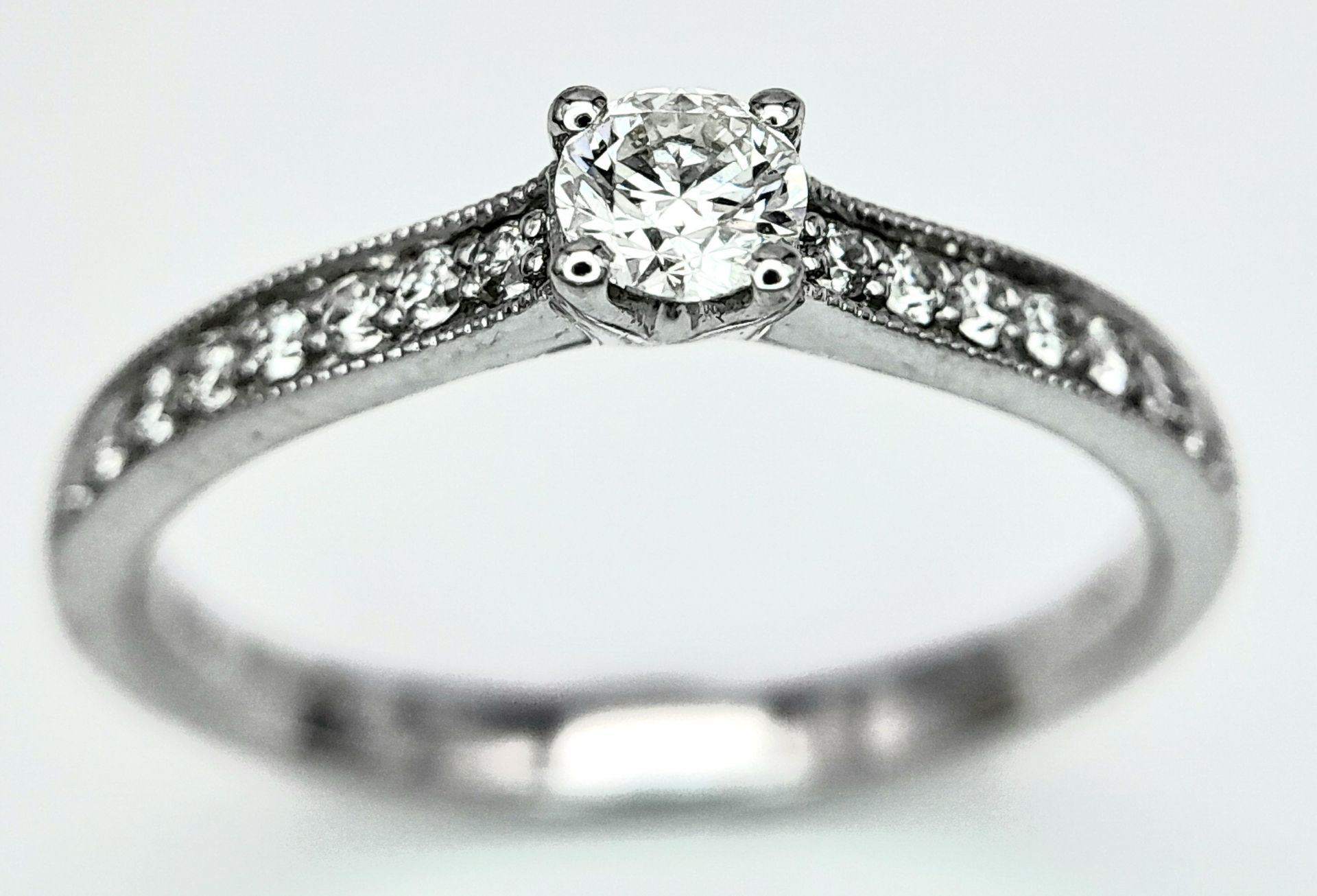 AN 18K WHITE GOLD DIAMOND SOLITAIRE RING - WITH DIAMOND SET SHOULDERS. 0.35CT. TOTAL 2.6G. SIZE N - Image 2 of 5