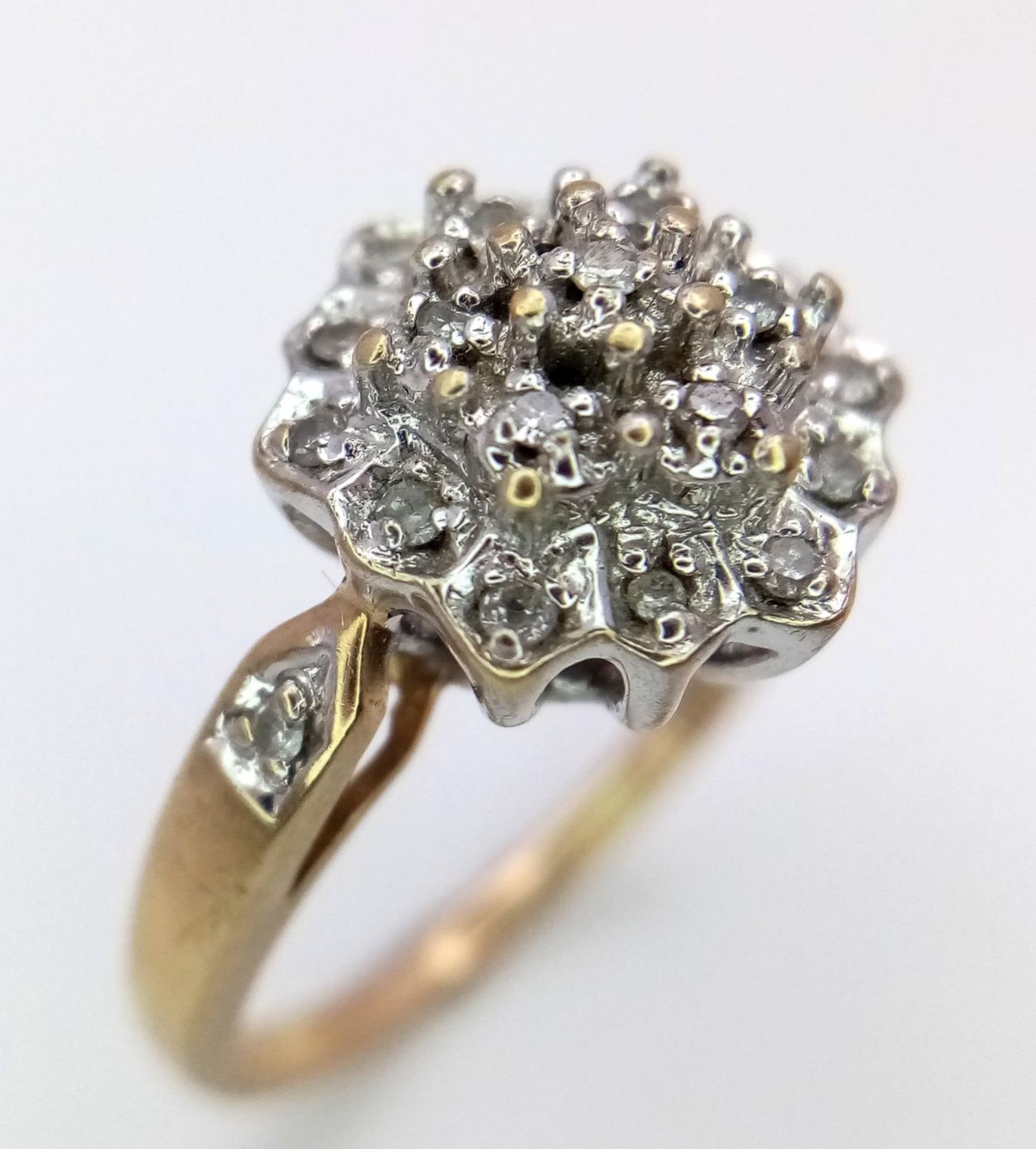 A 9K YELOW GOLD DIAMOND RING IN THE FLORAL DESIGN 0.20CT 3.6G SIZE O. SC 9003