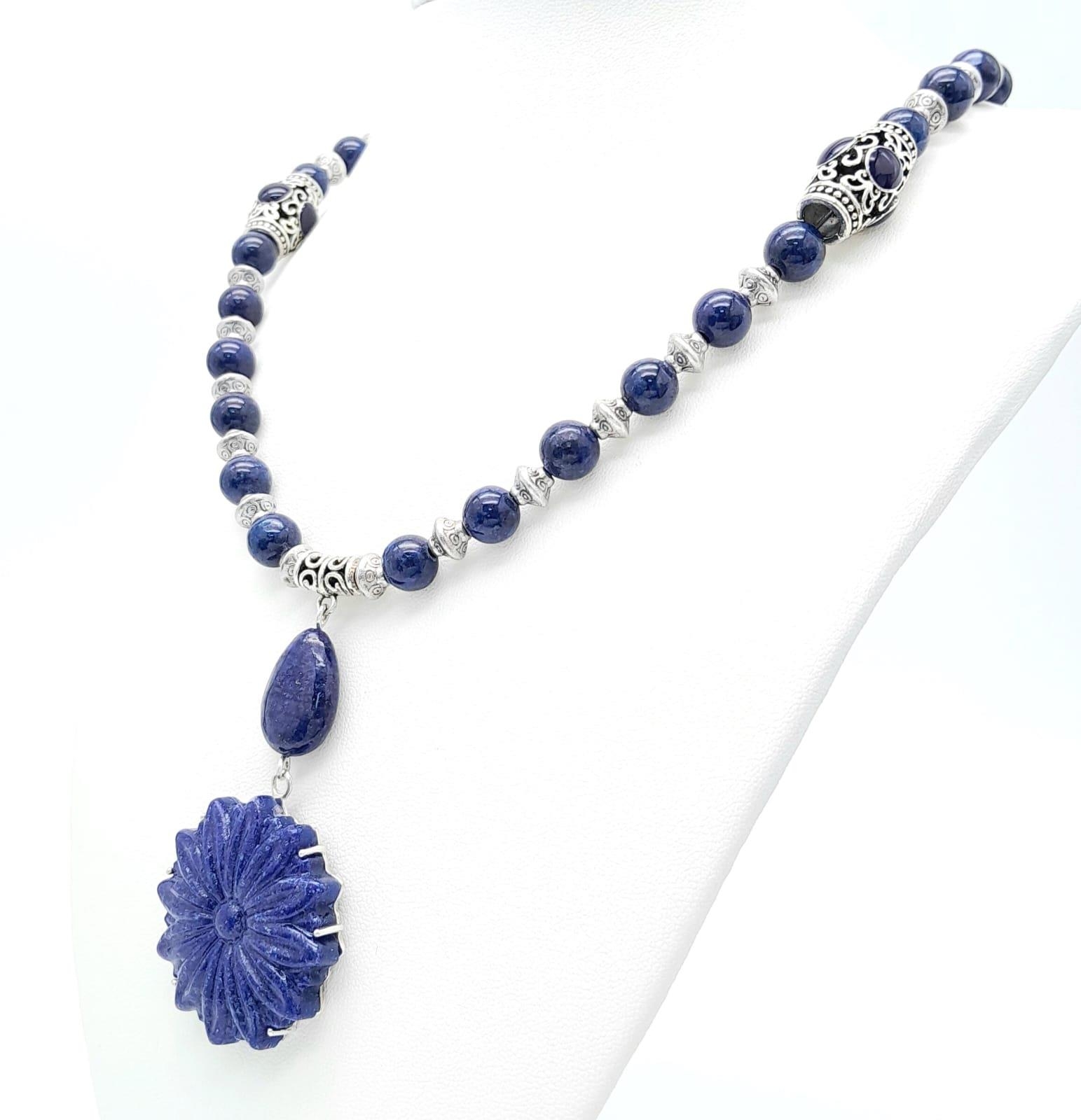 A Tibetan silver and lapis lazuli necklace and earrings set with large, carved, flower shaped discs. - Image 3 of 5