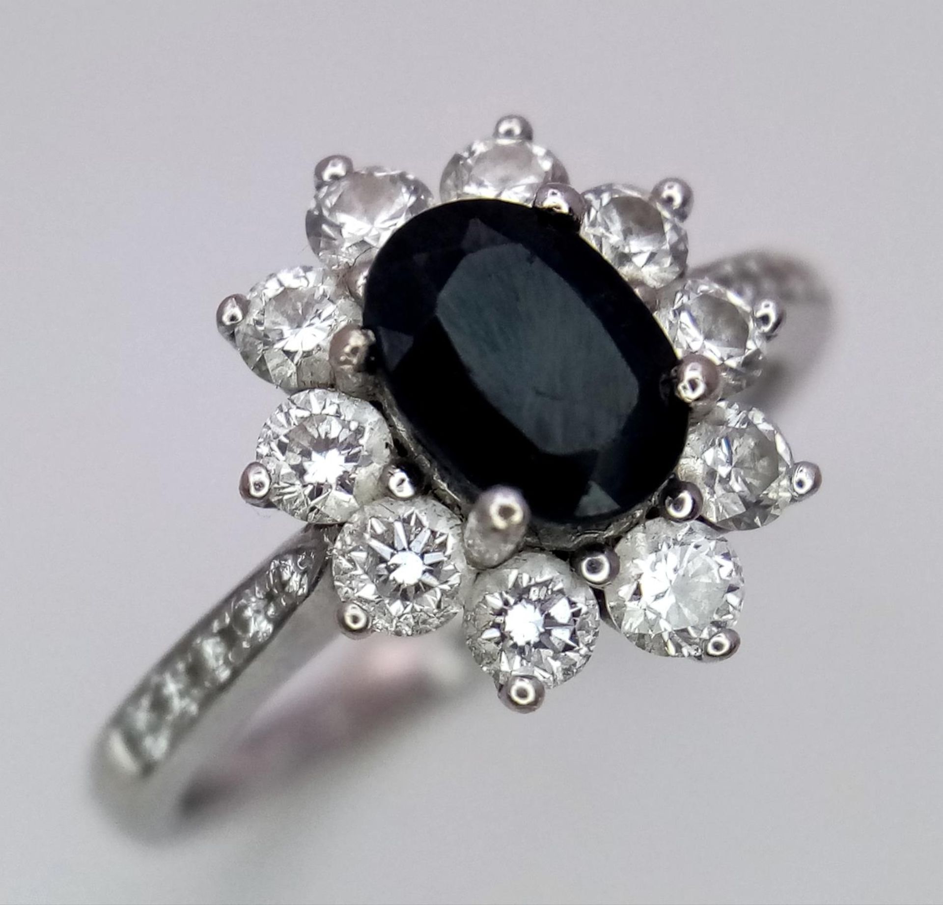 A 18K (TESTED AS) WHITE GOLD DIAMOND & SAPPHIRE CLUSTER RING 0.50CT DIAMONDS & 1CT OVAL SAPPHIRE 4.