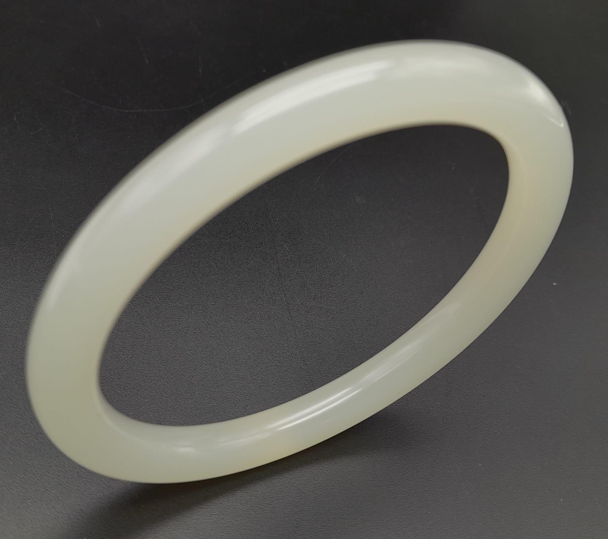 A Pale Green Thin Jade Bangle. 7mm width. 58mm inner diameter. - Image 2 of 3