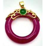 A Magenta Jade Pendant on Gilded Backing. 4cm length, 3cm diameter, 6.79g total weight.