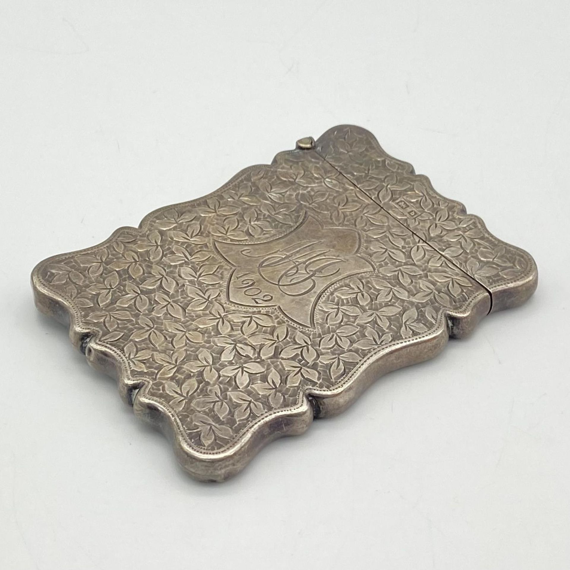 An Edwardian Sterling Silver Card Case. Floral engraving with monogram cartouche. Birmingham