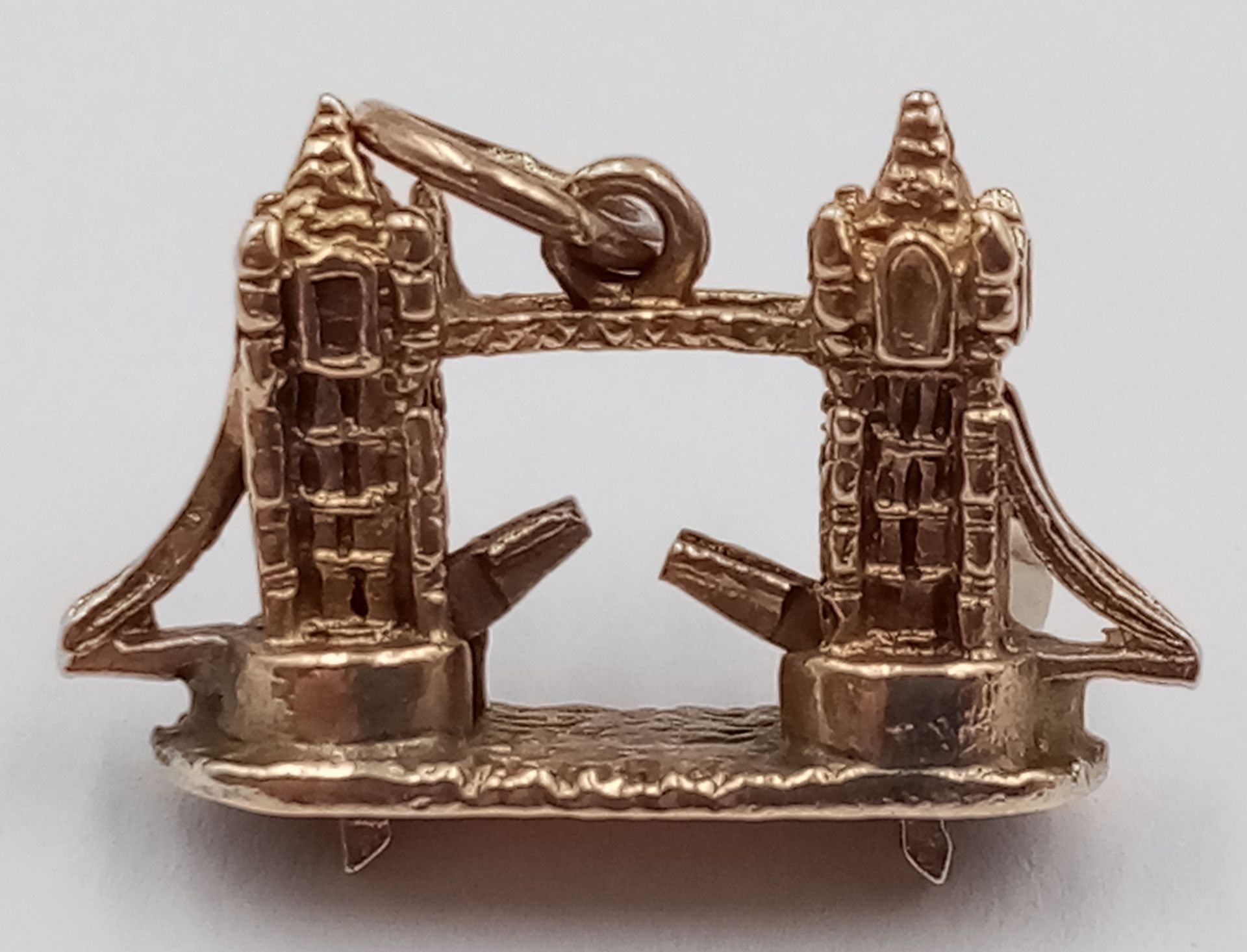 A 9K YELLOW GOLD LONDON TOWER BRIDGE CHARM, WITH MOVING PARTS WHERE THE BRIDGE LIFTS. 2cm x 1.5cm. - Image 2 of 3