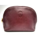 A Vintage Cartier Burgundy Pouch. Leather exterior with zip top closure. Burgundy canvas interior.