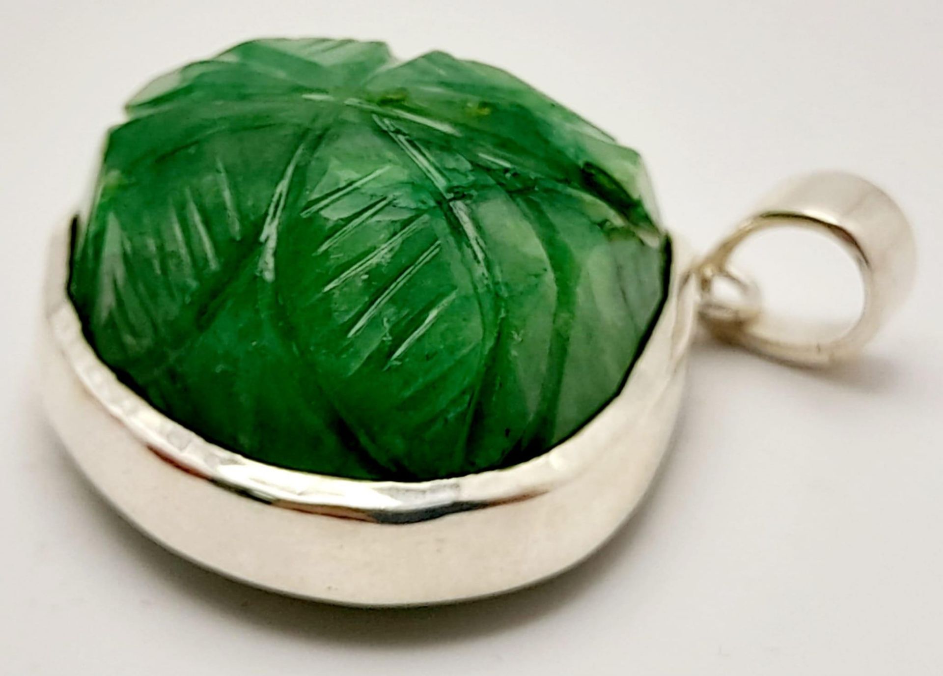 A Carved Trillion Shape 81ct Emerald Pendant set in 925 Silver. 4cm. Comes with a presentation case. - Image 3 of 6