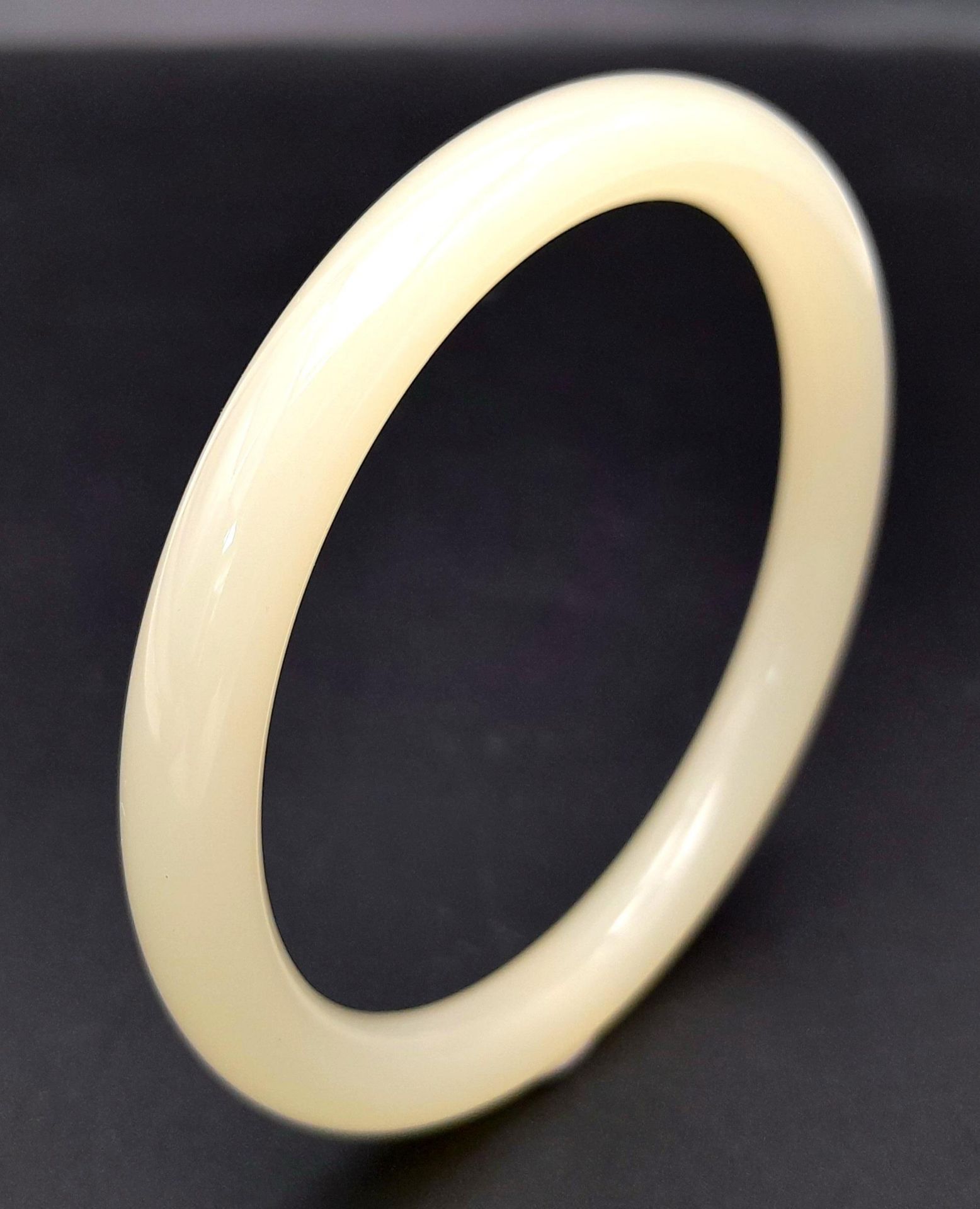 A Light Pastel Shade Thin Jade Bangle. 8mm width. 6cm inner diameter.