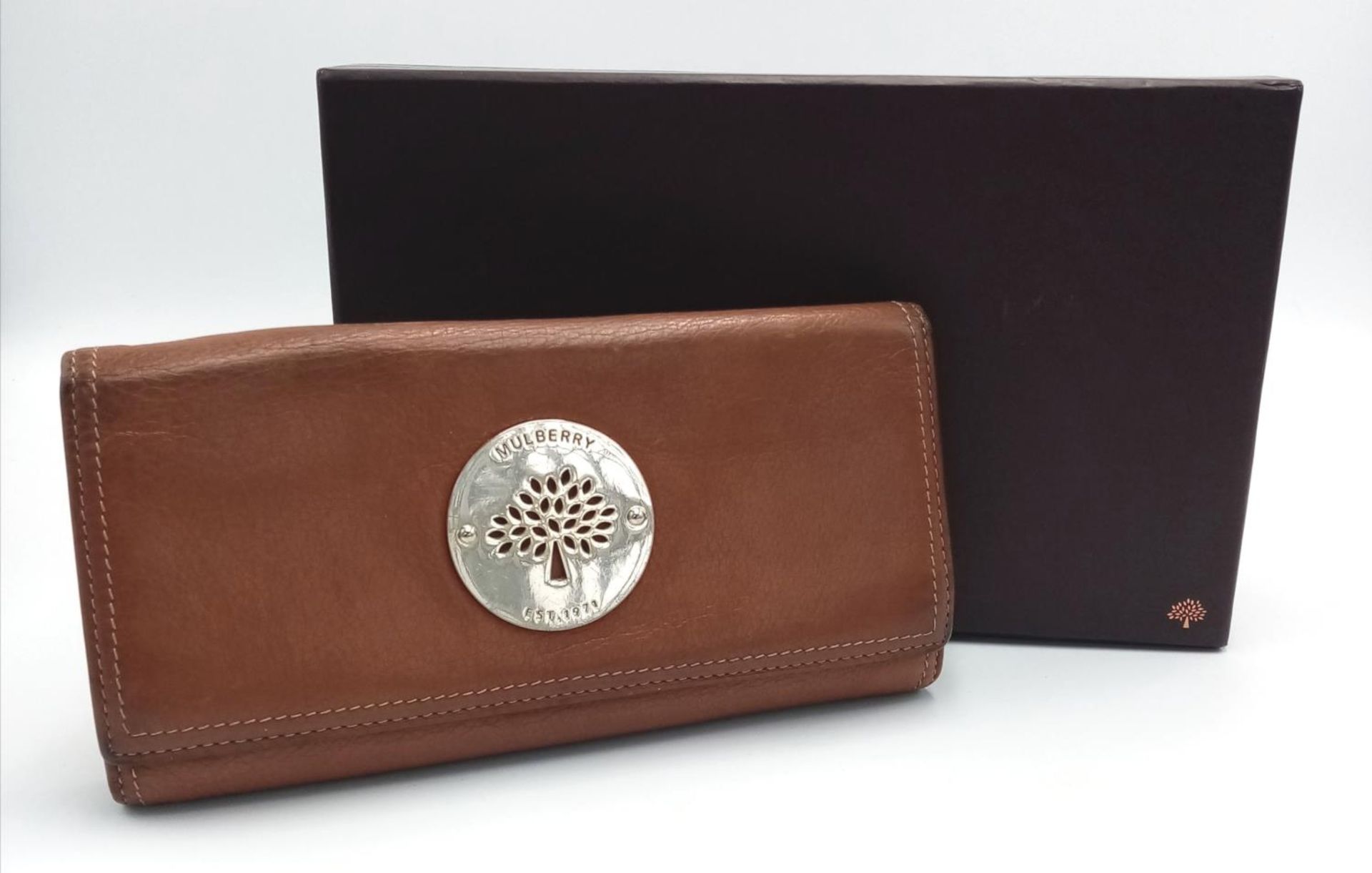 A Mulberry Brown Daria Continental Wallet. Leather exterior with gold-toned hardware, a zipped