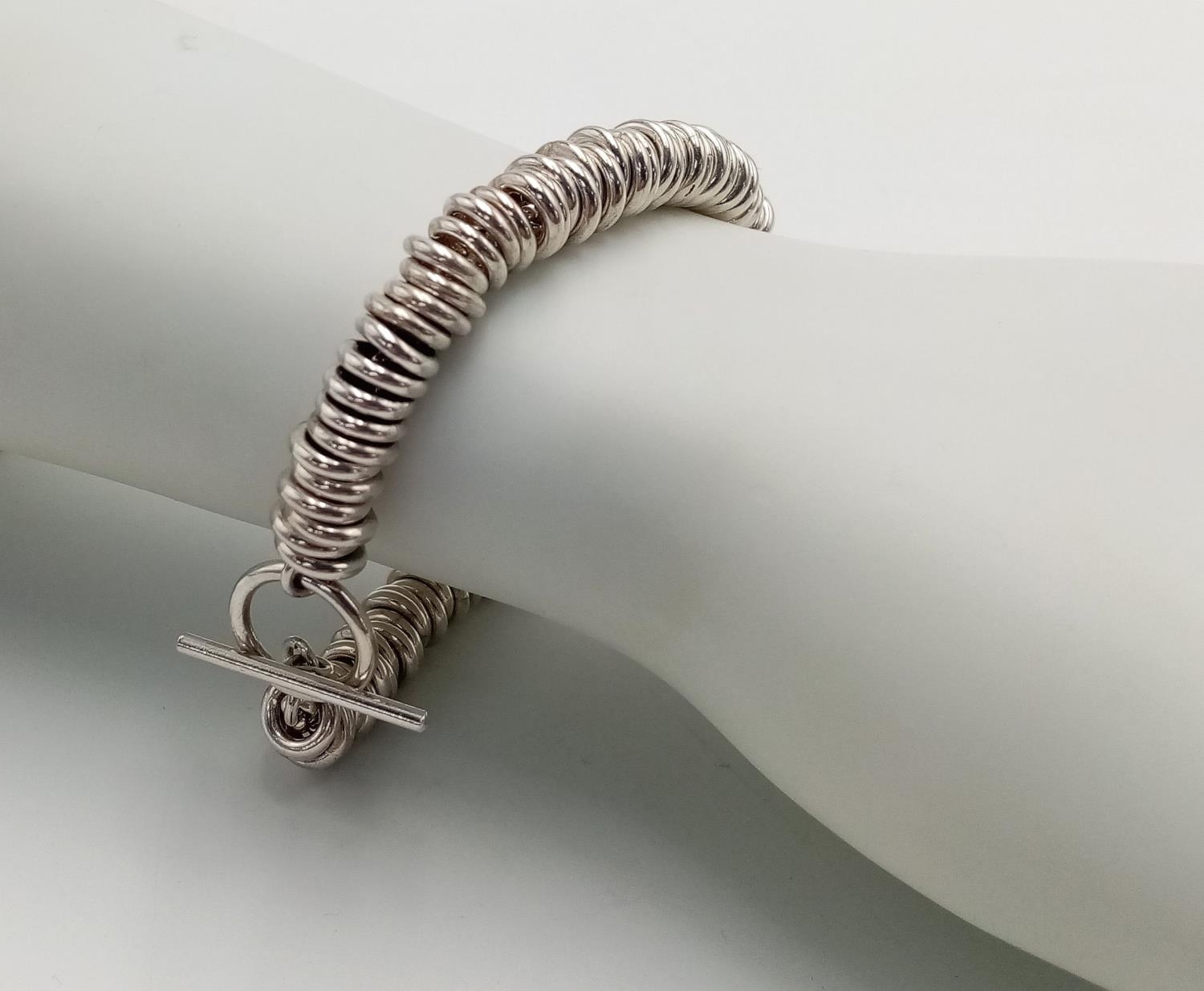 A STERLING SILVER RING LINKED BRACELET WITH T BAR CLASP 51.7G , APPROX 20CM. SC 9082