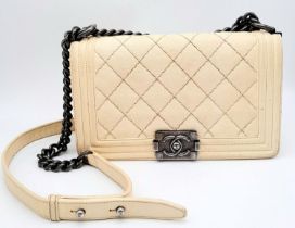 A Chanel Ivory Boy Bag. Leather exterior with chrome-toned hardware, chain and leather strap, and