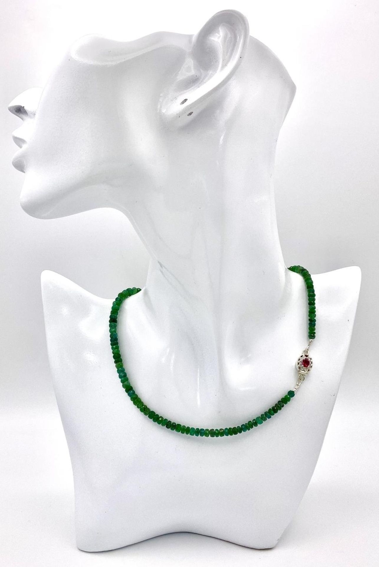 A 90ctw Single Strand Emerald Rondelle Necklace with a Ruby and 925 Silver Clasp. 42cm length. - Image 2 of 5