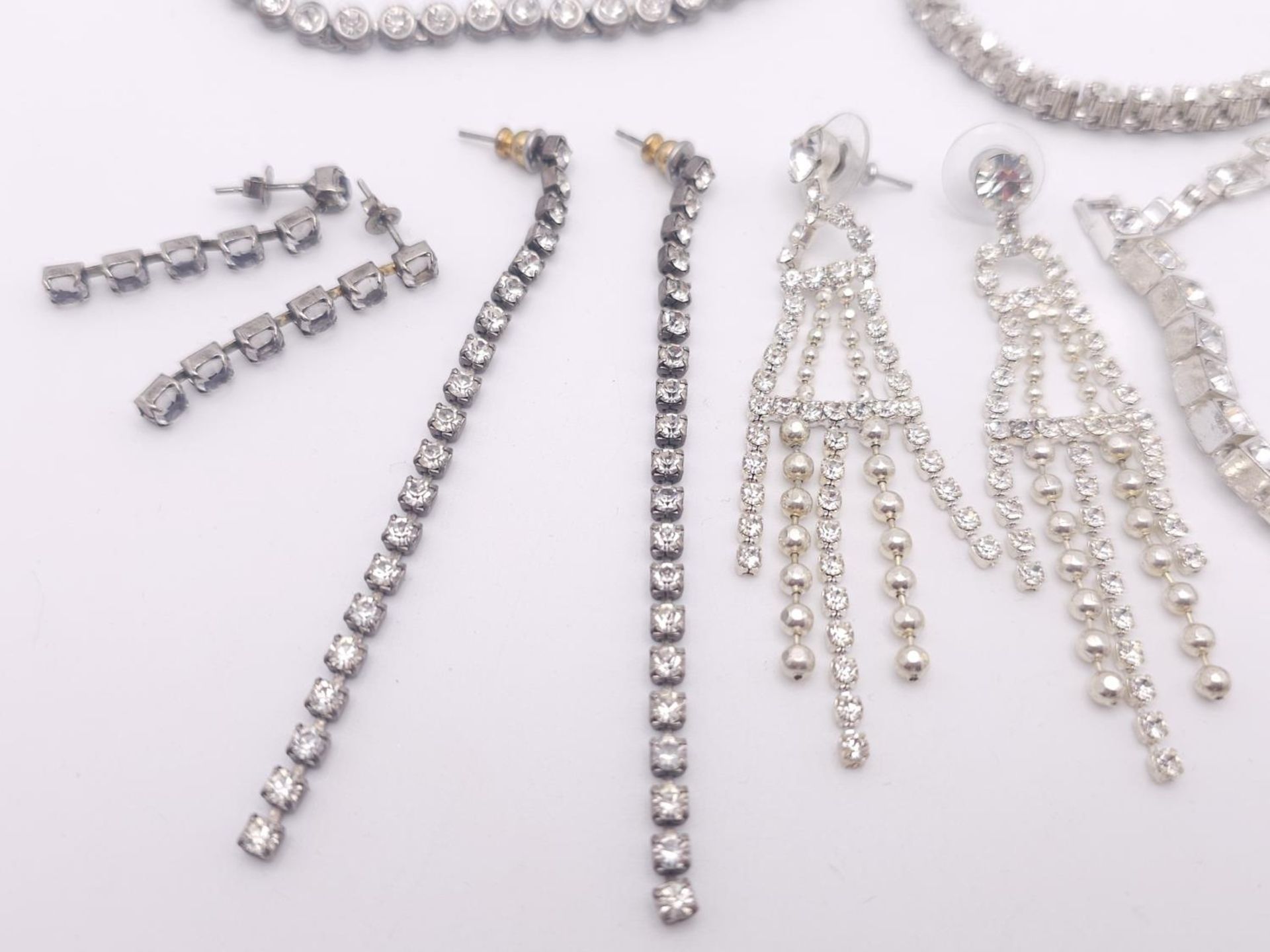 A White metal rhinestone costume bundle including 3x bracelets (all 19cm) and 3 pairs of earrings. - Bild 2 aus 5