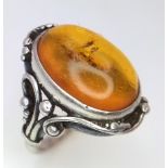 A Vintage or Antique, Ornate Mounted, Silver Amber Cabochon Ring Size S. Set with a 1.8cm Long Amber