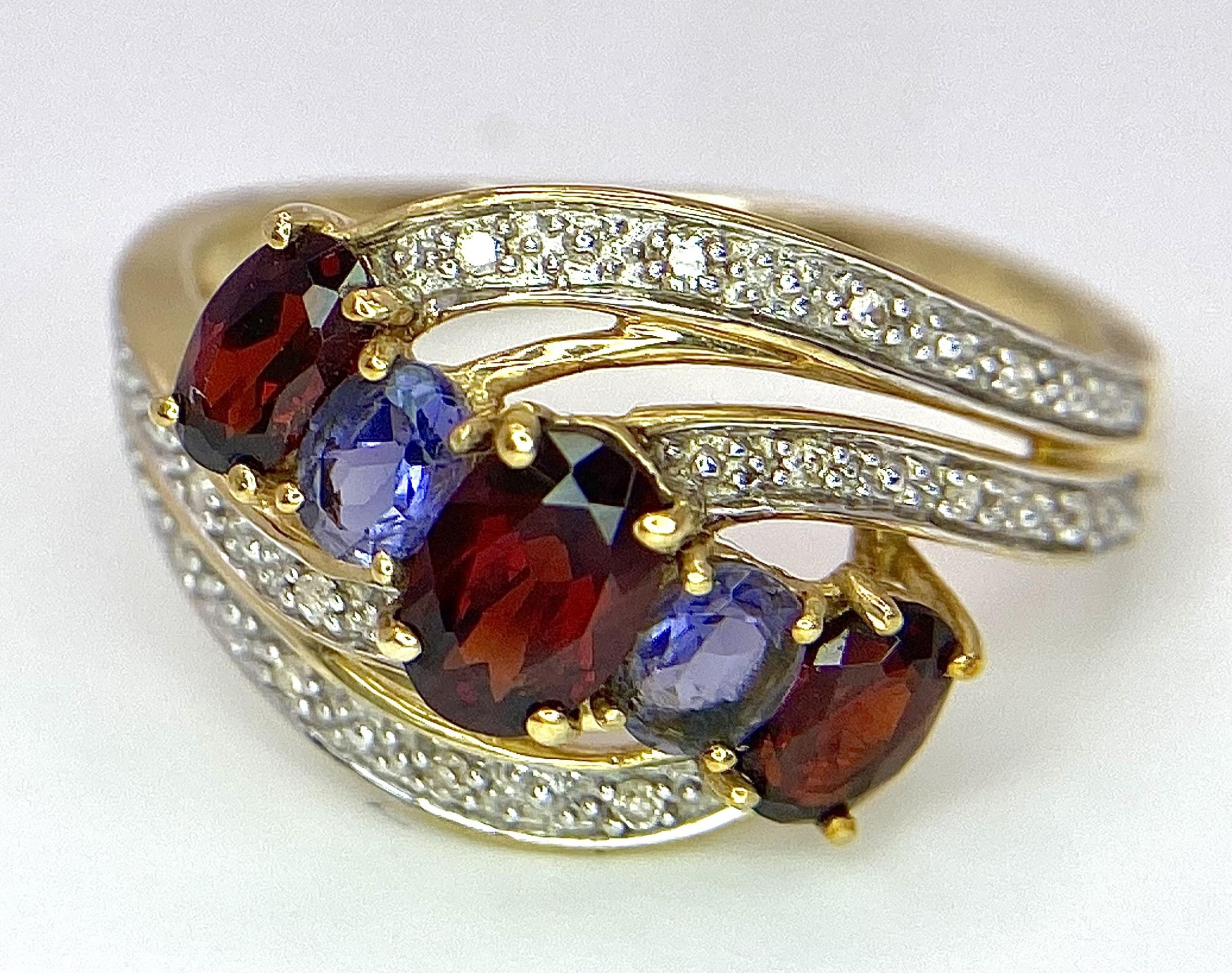 A 9 Carat Yellow Gold Garnet, Tanzanite and Diamond Set Crossover Ring Size P. Crown Measures 1. - Image 4 of 7