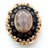 An Antique Victorian 15K Gold (tested) and Black Enamel Mourning Brooch. Oval shape with scrolled