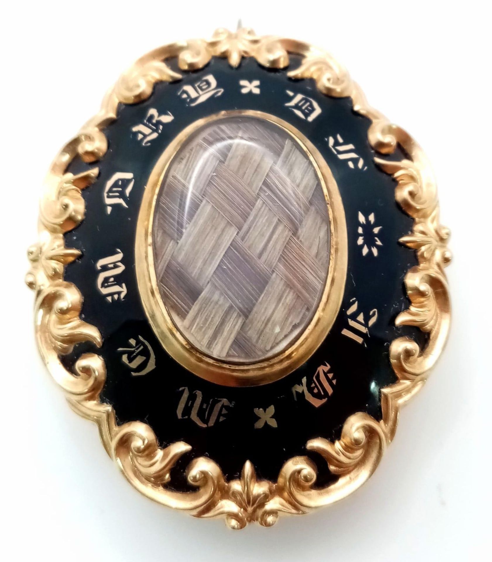 An Antique Victorian 15K Gold (tested) and Black Enamel Mourning Brooch. Oval shape with scrolled