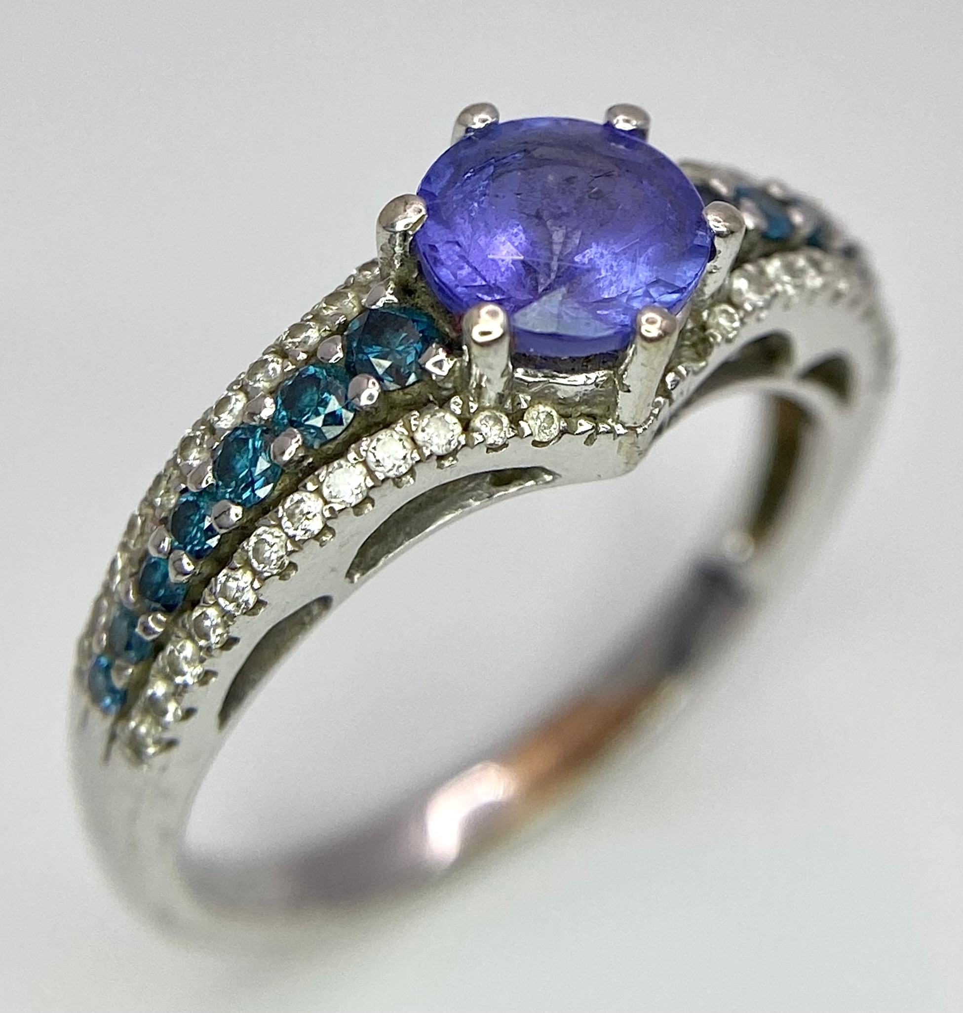 A 14K White Gold Tanzanite and Diamond Ring. Central oval cut tanzanite with blue and white diamonds - Image 2 of 8