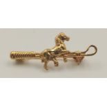 An 18 K yellow gold of riding interest depicting a horse and a riding crop, pin in excellent