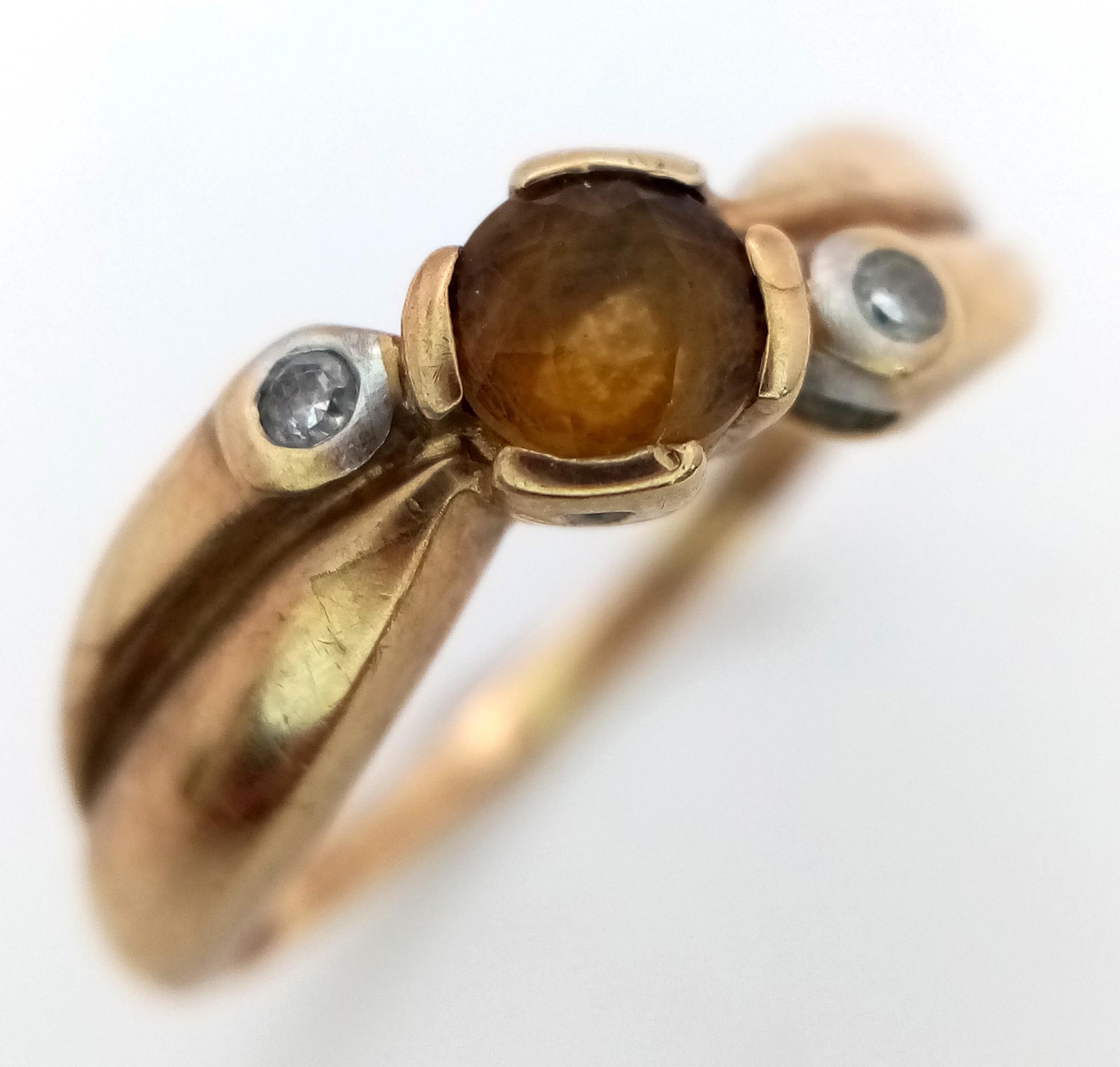 A 9K Yellow Gold Citrine and Diamond Crossover Ring. Size J. 1.8g total weight.