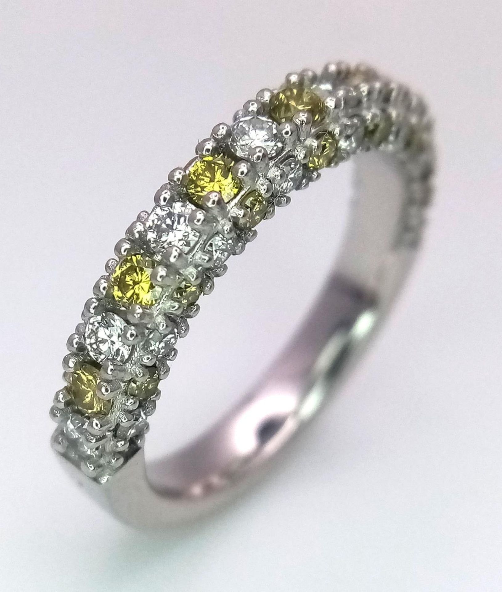 A Platinum White and Yellow Diamond Three-Sided Half Eternity Ring. Size L. 6.3g total weight.