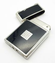 A Vintage Givenchy Black Enamel Lighter. Needs gas and flint. 5cm x 3.5cm. UK sales only.