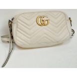 A Gucci Ivory GG Marmont Cross Body Bag. Quilted leather exterior with gold-toned hardware, chain