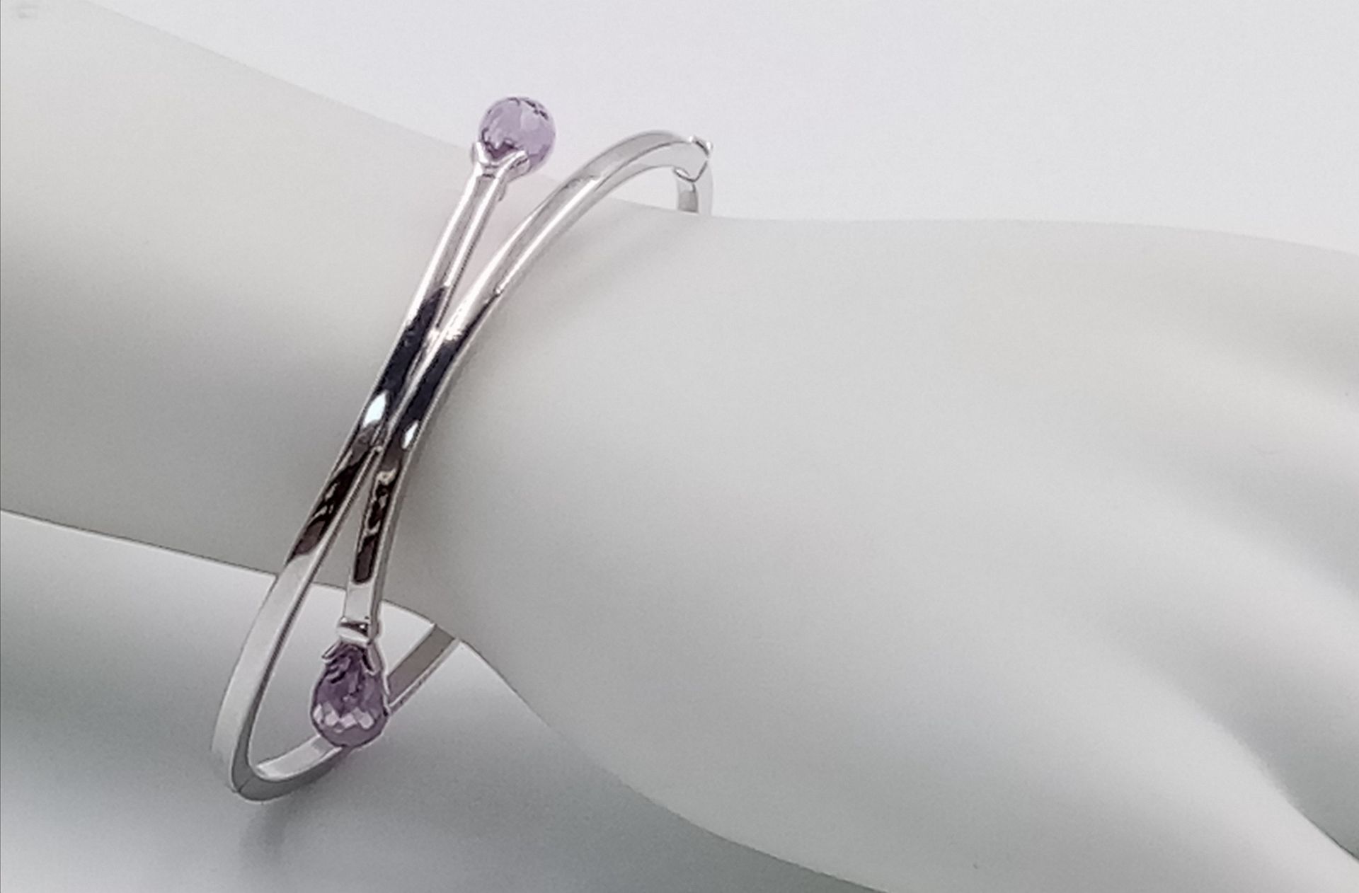 A 9K WHITE GOLD AMETHYST SET BANGLE. 8.1G.