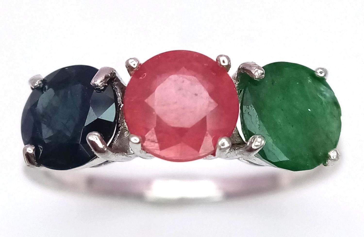 An Emerald, Sapphire and Ruby Three Stone Ring on 925 Silver. Size N1/2, 2.4g total weight.