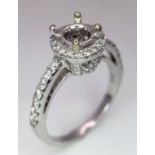 AN 18K WHITE GOLD DIAMOND HALO SOLITAIRE RING MOUNT WITH DIAMOND SET SHOULDERS. Ready to set your